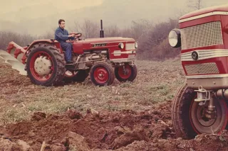 Historický snímek traktoru ZETOR 3511 s řidičem při práci na poli.